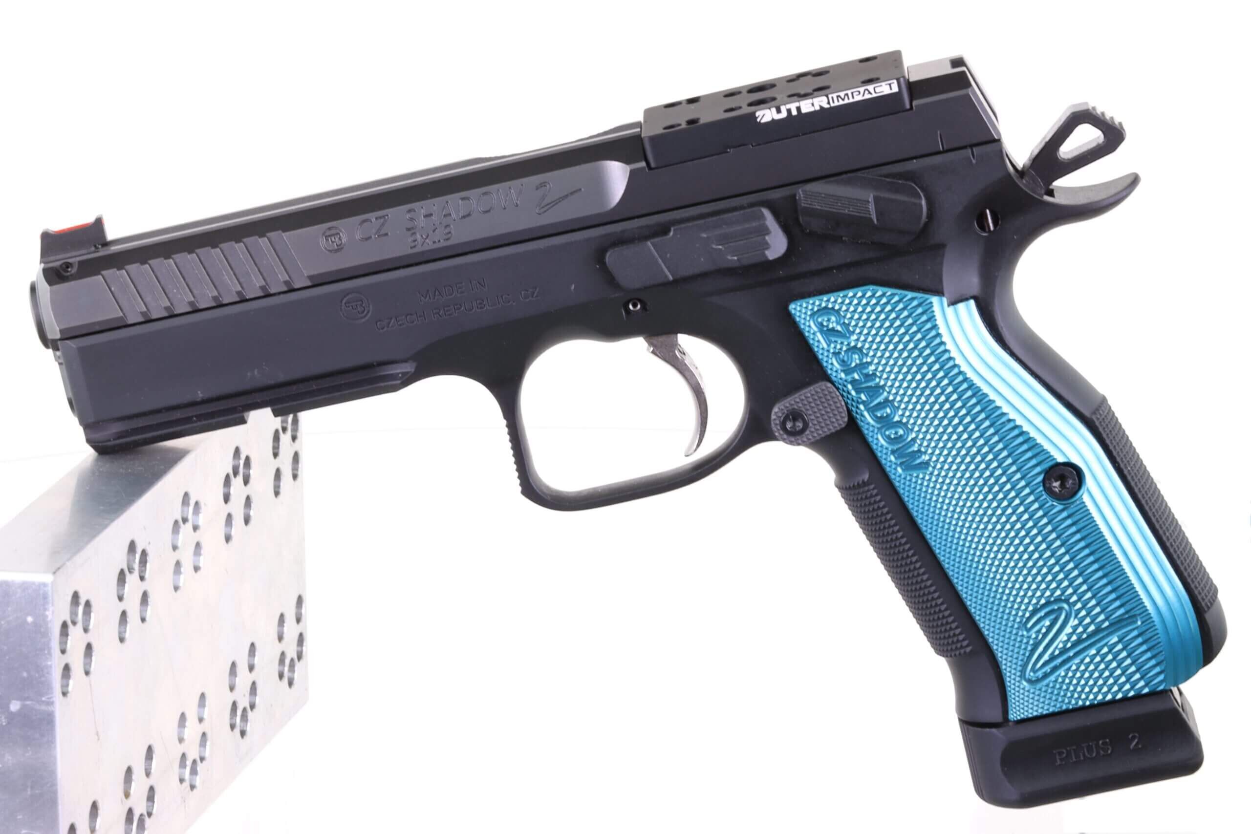 CZ Shadow 2 Waffe mit blauem Griff seitlich auf einem Metallblock liegend